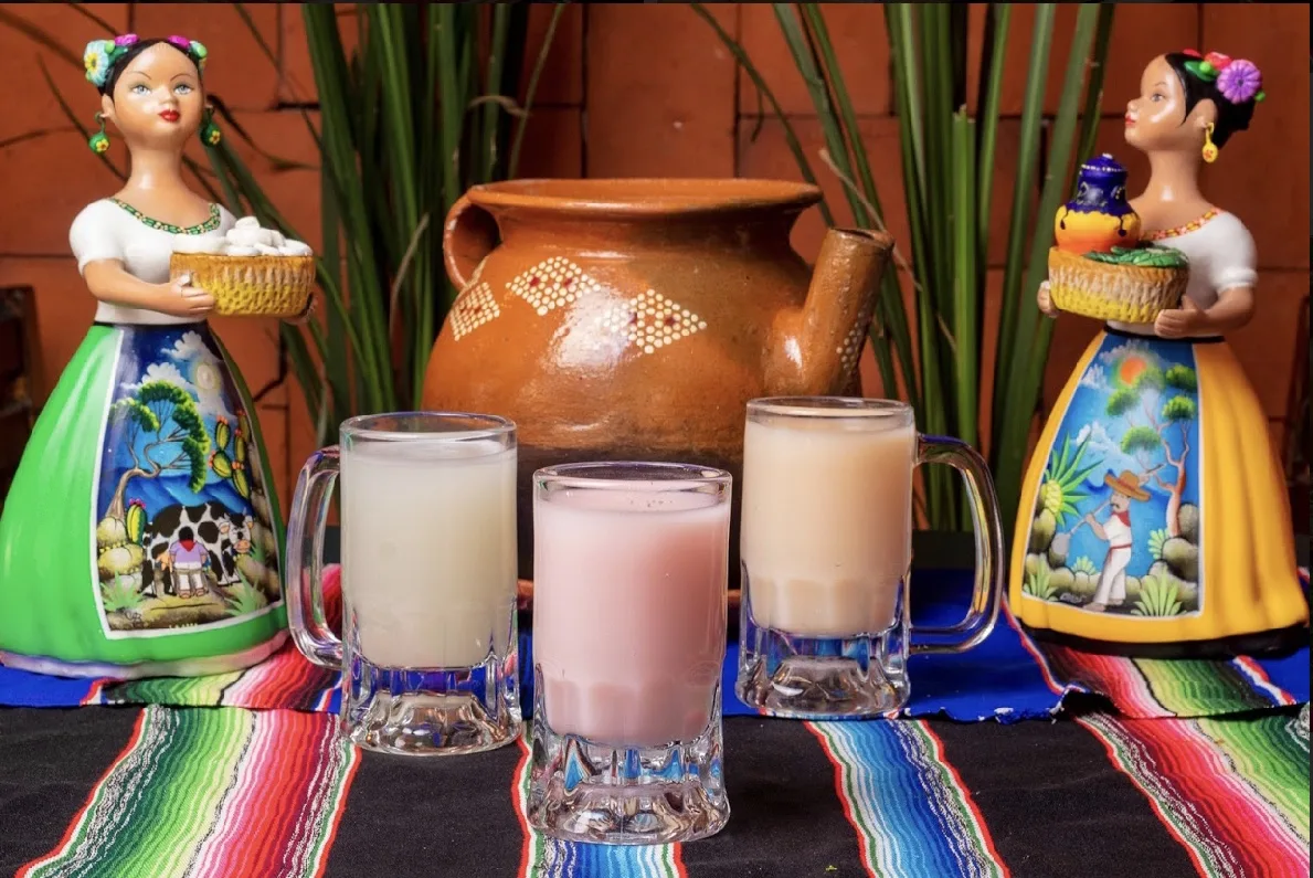 Pulque curado de sabores en jarro de barro tradicional