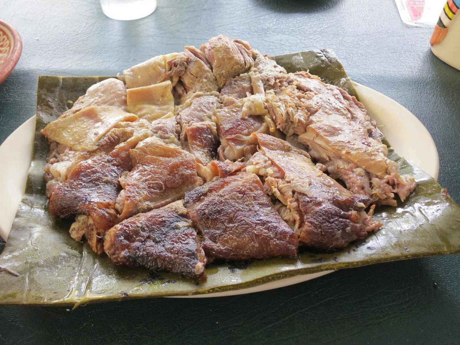 Barbacoa de hoyo recién servida en penca de maguey