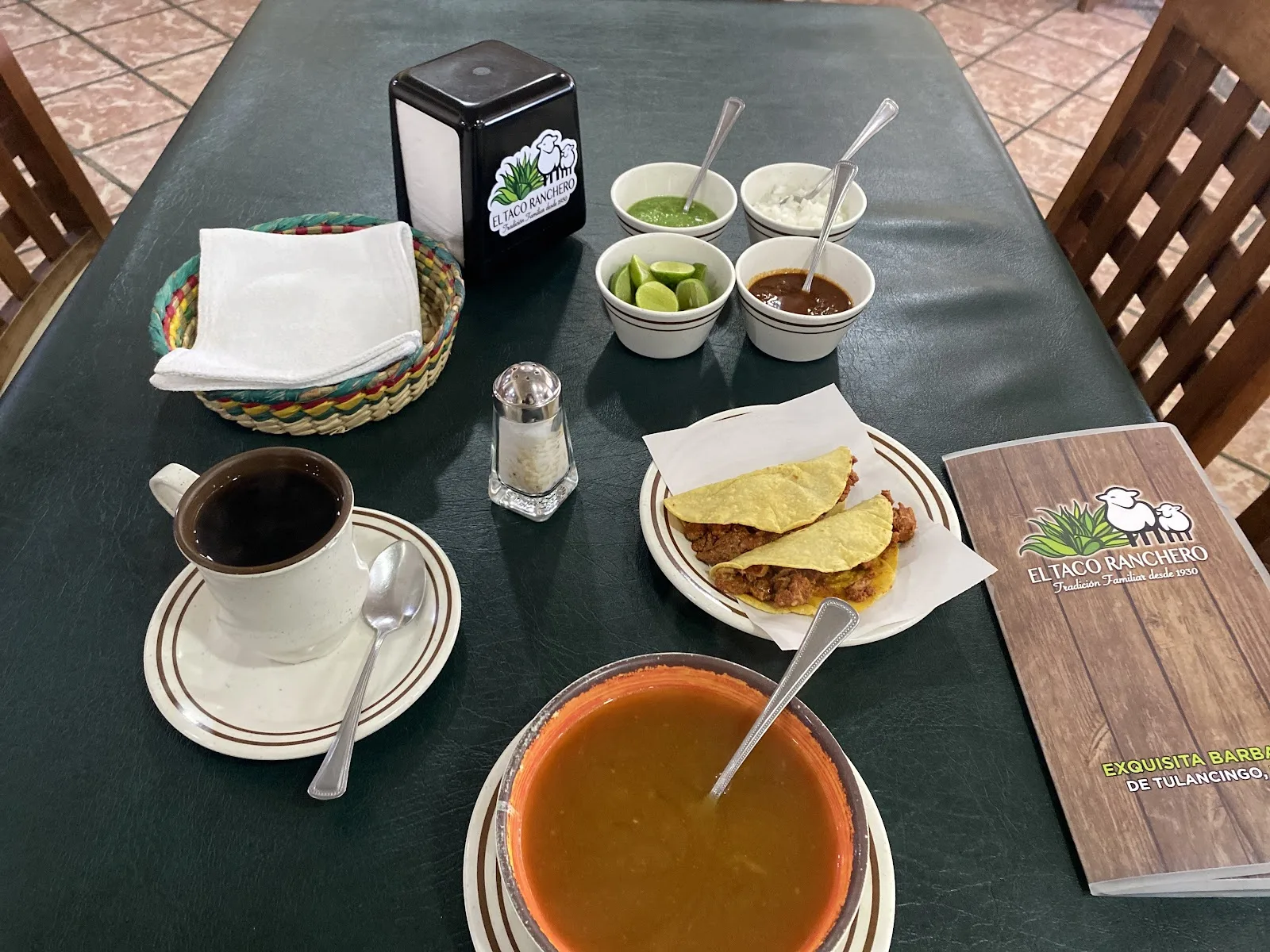 Mesa con tacos, consomé y micheladas en la terraza